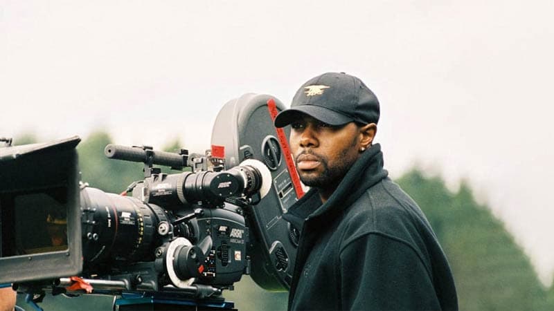 Director Antoine Fuqua on the film set, positioned next to the camera, actively directing a movie.